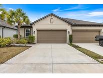 Home featuring a large concrete driveway and a well-maintained front lawn at 6077 Amberly Dr, Bradenton, FL 34208