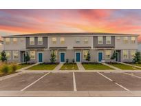 Well-maintained two-story townhomes with blue front doors, landscaping, and ample parking spaces at 16606 San Nicola Pl, Lakewood Ranch, FL 34211