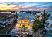 Stunning coastal home with pool, dock, and bay views at sunset at 718 Key Royale Dr, Holmes Beach, FL 34217