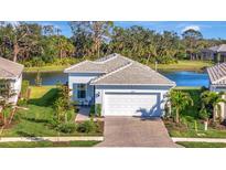 Beautiful single-story home featuring manicured lawn, brick driveway, and a two-car garage at 25532 Royal Tern Ln, Englewood, FL 34223
