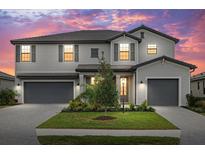 Beautiful two-story home featuring a well-manicured lawn, a two-car garage and colorful sunset at 4886 Seafoam Trl, Bradenton, FL 34211