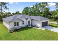 Modern single-story home featuring a lush green lawn, new roof, neutral color palette, and an attached two-car garage at 1342 Shaker Ln, North Port, FL 34286