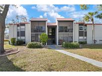 Inviting condo exterior featuring a red tile roof, balconies, and landscaped grounds at 3201 Beneva Rd # 204, Sarasota, FL 34232