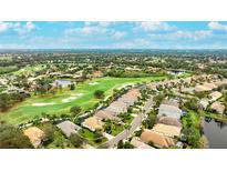 Stunning aerial view of the home with golf course frontage and beautiful landscaping in a desirable community at 7244 Orchid Island Pl, Bradenton, FL 34202