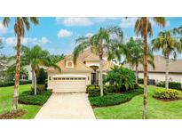 Charming single-story home featuring a two-car garage and lush tropical landscaping, set under a sunny sky at 7244 Orchid Island Pl, Bradenton, FL 34202
