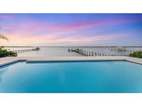 Stunning waterfront view from the pool overlooking the ocean and docks at sunset at 7416 Riverview Dr, Bradenton, FL 34209