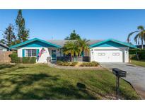 Charming single-story home with blue accents, well-manicured lawn, and an American flag at 807 62Nd W St, Bradenton, FL 34209