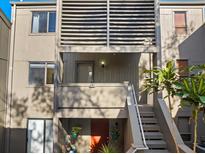 Exterior shot of condo showcasing the walkway and the orange front door, with potted plants and a small balcony at 235 Woodland Dr, Osprey, FL 34229