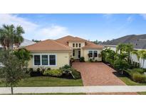 Lovely single-story home featuring a tile roof, manicured landscaping, and a brick driveway at 4839 Pastel Ct, Sarasota, FL 34240