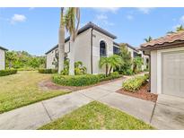 Charming condo exterior with lush landscaping, palm trees, and neutral paint scheme at 6705 Grand Estuary Trl # 201, Bradenton, FL 34212