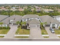 An aerial view shows the home and surrounding neighborhood with paved driveways and tropical landscaping at 1012 Fernleaf Run, Bradenton, FL 34212