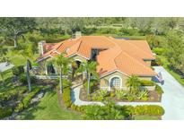 Stunning single-story home with a clay tile roof, beautiful landscaping, and a curved walkway at 4221 Escondito Cir, Sarasota, FL 34238
