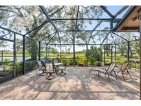 Enclosed patio featuring brick flooring, with views of the lake and landscaping at 5724 Doral Dr, Sarasota, FL 34243