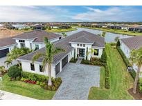 Stunning waterfront home with lush landscaping, paver driveway, and attached two-car garage at 9048 Bernini Pl, Sarasota, FL 34240