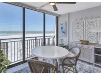 Bright dining area featuring stylish wicker chairs, coastal decor, and panoramic ocean views at 20 Whispering Sands Dr # 306, Sarasota, FL 34242