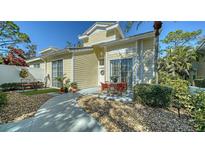 Charming light yellow home with a walkway, a front patio with table, and manicured landscaping at 7628 Whitebridge Gln, University Park, FL 34201