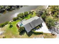 An aerial view shows the property near the water with pool and lush landscaping at 2458 Whippoorwill Cir, Sarasota, FL 34231