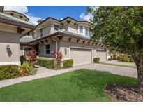 Beautiful townhome exterior featuring a two-car garage, and lush landscaping at 6409 Moorings Point Cir # 102, Lakewood Ranch, FL 34202