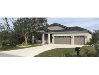 Charming single-Gathering home boasts a two-car garage, well-manicured lawn and landscaping at 15079 Wichita Rd, Port Charlotte, FL 33981