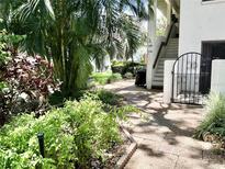 Inviting entryway with a walkway, palm trees, manicured landscaping, and units 119 and 120 at 3500 El Conquistador Pkwy # 119, Bradenton, FL 34210