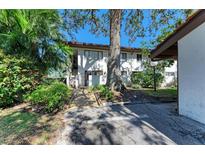 Charming two-story building with lush landscaping, mature trees, and a tile roof at 3500 El Conquistador Pkwy # 119, Bradenton, FL 34210