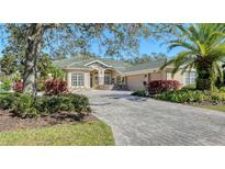 Well-maintained home with a meticulously landscaped front yard and a brick-paved driveway, offering curb appeal at 12471 Natureview Cir, Bradenton, FL 34212