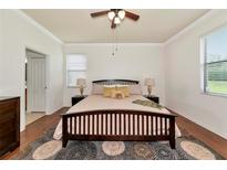 Spacious bedroom featuring wood floors, ceiling fan, ensuite bath and large window for ample natural light at 6814 Willowshire Way, Bradenton, FL 34212
