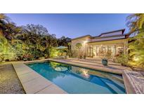Inviting backyard pool with lush landscaping, lounge chairs, and a seamless indoor-outdoor living transition at 2434 Wood St, Sarasota, FL 34237