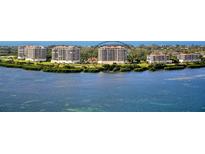 Scenic aerial view of beachfront condos overlooking serene waters and lush green landscapes at 3060 Grand Bay Blvd # 154, Longboat Key, FL 34228