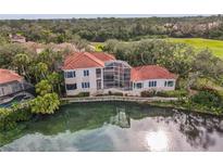 Beautiful waterfront home with a red tile roof, screened lanai and lush landscaping at 7460 Monte Verde, Sarasota, FL 34238