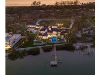 Stunning waterfront estate featuring a private dock, pool, and lush landscaping, perfect for luxury living at 8501 Midnight Pass Rd, Sarasota, FL 34242