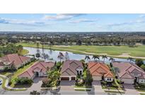 Stunning aerial view of homes on a waterfront property adjacent to lush golf course at 15608 Leven Links Pl, Lakewood Ranch, FL 34202