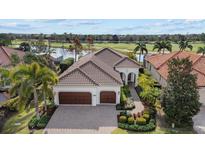 Elegant home with a tile roof, three-car garage, and meticulously landscaped front yard at 15608 Leven Links Pl, Lakewood Ranch, FL 34202