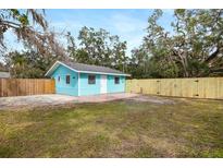 Charming light blue home featuring a brick patio and newly installed wood fence at 3200 Tobero Ln, Sarasota, FL 34235
