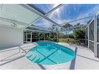 A private in-ground screened pool with a bright white deck and ceiling fan is ready for relaxation and entertaining at 4410 70Th E Dr, Sarasota, FL 34243
