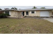 Single story home featuring a two car garage and a lawn in need of maintenance at 600 S Neponsit Dr, Venice, FL 34293