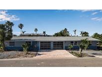 Charming single-story home featuring a two-car garage and a beautifully paved driveway at 765 Saint Judes N Dr, Longboat Key, FL 34228
