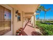 Inviting exterior view with a walkway, vibrant flowers, and a glimpse of the marina at 260 Santa Maria St # 110, Venice, FL 34285