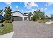 Beautiful single-Gathering home with an attached garage, lush landscaping, and a brick driveway at 12029 Perennial Pl, Lakewood Ranch, FL 34211