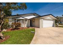 Charming single-story home featuring a brick facade, attached garage, and well-manicured landscaping on a sunny day at 5500 Bayou Grande Ne Blvd, St Petersburg, FL 33703