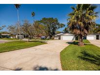 Inviting single-story home with an attached garage, spacious driveway, lush lawn, and mature trees at 5500 Bayou Grande Ne Blvd, St Petersburg, FL 33703