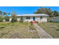 Charming single-story home featuring a metal roof, a blue front door, and a simple landscaped yard at 2302 8Th W Ave, Bradenton, FL 34205