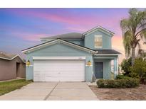 Charming two-story home featuring a well-maintained lawn, complemented by a two car garage, and a cozy front porch at 2347 Richwood Pike Dr, Ruskin, FL 33570