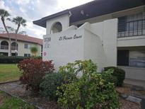 Condominium building with a well-maintained lawn and manicured bushes at 3720 El Poinier Ct # 515, Sarasota, FL 34232