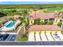 Stunning aerial view of the home with a terracotta roof, pool, golf course, and lush green landscape at 7149 River Hammock Dr # 101, Bradenton, FL 34212