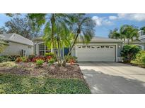 Charming home featuring a two-car garage, vibrant landscaping, and a well-manicured front yard at 92 Tall Trees Ct, Sarasota, FL 34232