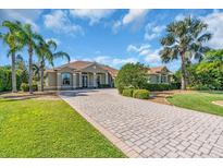 Charming home with a paver driveway, mature trees, and lush landscaping at 3336 Lakeside Cir, Parrish, FL 34219