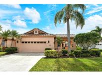 Charming single-story home featuring a tile roof, manicured lawn, and a two-car garage at 3814 Mira Lago Dr, Sarasota, FL 34238