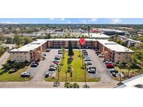 A three-story condominium community with well-maintained landscaping and ample parking at 4126 Heron Way # B113, Bradenton, FL 34205