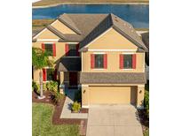 An aerial view of a two-story home with a scenic pond in the background at 14318 Fissore Blvd, Wimauma, FL 33598